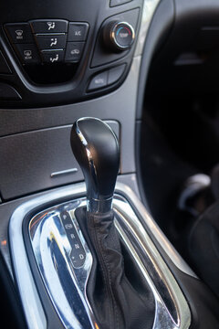 Automatic gear selector lever located on center console of modern vehicle interior. Modern automobile design focuses on comfortable driving control and ergonomic transimission handling.