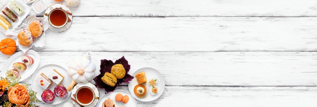 Autumn theme afternoon tea corner border against a white wood banner background. Pumpkin and apple theme savory finger foods, sandwiches, scones, and desserts. Overhead view with copy space.