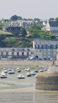 Daytime video of Binic port in Brittany, France, showing small boats resting on the mudflats at low tide.