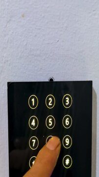 Finger pressing digital keypad password pin code for secure door entrance access authentication. Hand dialing combination number on black electronic touch screen lock privacy safety technology.