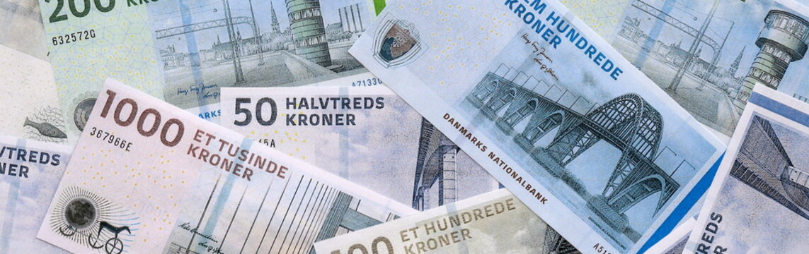 Danish krone money bills pile on table. Denmark banknotes of DKK currency close up.
