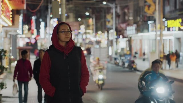 Night market commuter. City night traveler moves quietly. Urban resident strolls through bustling evening market. Nighttime city resident navigating lively market street with alertness