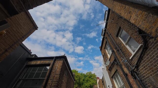 Timelapse of clouds moving above brick rooftops in London
