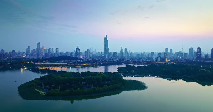 Nanjing skyline with Tower beside Xuanwu Lake at blue hour, Jiangsu, China, showcasing urban architecture, waterfront scenery, and metropolitan tourism.