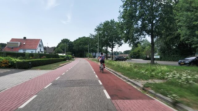 Woman cycling through Dutch countryside
