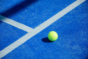 Obraz premium Single yellow padel ball resting on white line on blue synthetic court The Concept of precision and sports strategy