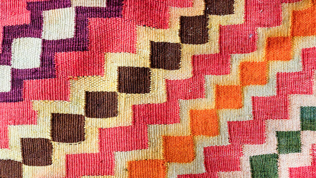 Handmade wool kilim rug featuring a colorful geometric zigzag pattern and patchwork texture, showcasing traditional ethnic weaving and vibrant textile craftsmanship