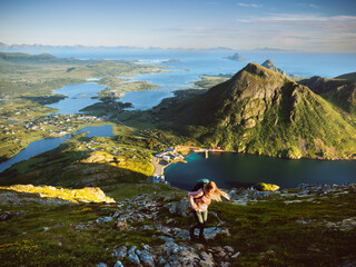 Fototapeta premium Woman traveler hiking in northern Norway travel solo active summer vacations, girl tourist climbing mountain healthy lifestyle tour explore offbeat trails in Vesteralen