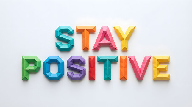 The phrase stay positive spelled out with colorful plastic magnetic letters on a clean white background for motivational concepts