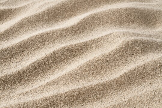 Textural Sand Dunes Close Up with Wavy Patterns on a Sunny Beach Surface