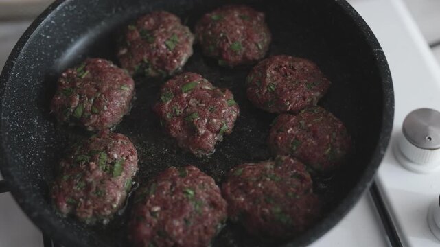 Close-up of traditional Turkish meatballs (k&ouml;fte) sizzling in a black cast iron skillet
