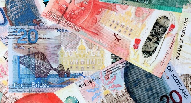 Scottish pound money bills in pile on table. Scotland GBP currency cash close up