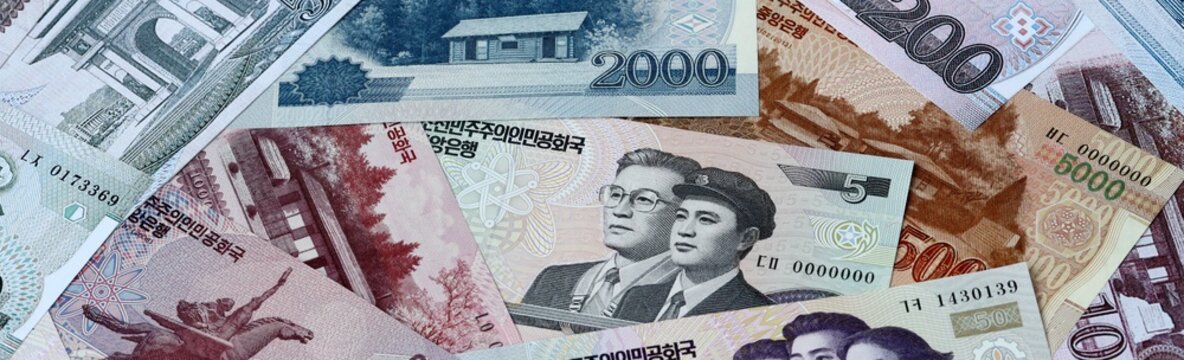 North Korean won money bills in pile on table. North Korea KPW currency cash close up