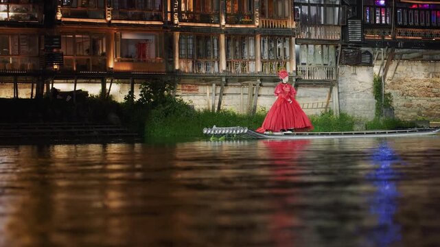 Night riverside asian woman in red gown slowly walking past historic wooden houses, amber lights reflecting on water, moody solitary atmosphere, fashion portrait with gentle river reflections