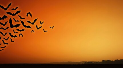 Fototapeta premium Spooky Halloween orange sky background with heavy swarm of bats and copy space