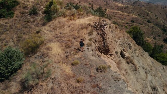 Man walking steadily along a rugged mountain ridge, embracing solitude and adventure, radiating self-reliance and freedom for outdoor enthusiasts and corporate leaders alike for campaign and editorial