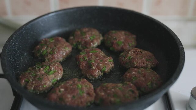 Close-up of traditional Turkish meatballs (k&ouml;fte) sizzling in a black cast iron skillet
