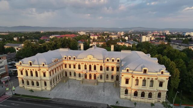Aerial drone pan of the Bacău Prefecture, also known as the Administrative Palace &mdash; a grand neoclassical government building in Romania under a dramatic evening sky.