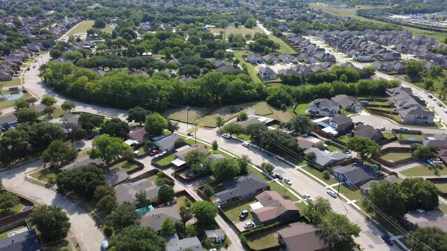 Thick woodland corridors frame residential blocks in Lyons Crest Estates within suburbs DFW. Paved streets route traffic through single family housing areas tree lined buffer zones, Garland, TX