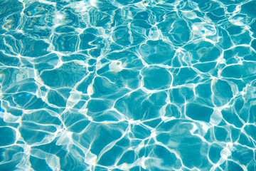 Fototapeta premium Summer vacation at ocean shore. Blue ocean rippled water texture reflection. Ripple water in summer pool. Sea surface background. Vacation resort water background. Sea beach