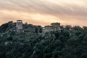 Fototapeta premium Historic Stone Tower and Traditional Mani House on a Hill at Sunset, Rural Greece Landscape