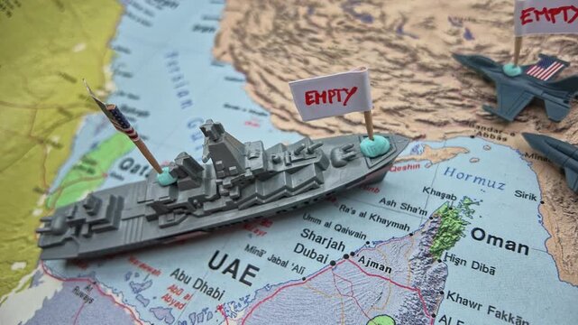 Military supply shortage concept with miniature US warship and fighter jets marked with empty signs on a map of the Gulf of Oman, representing defense logistics pressure and munitions depletion.