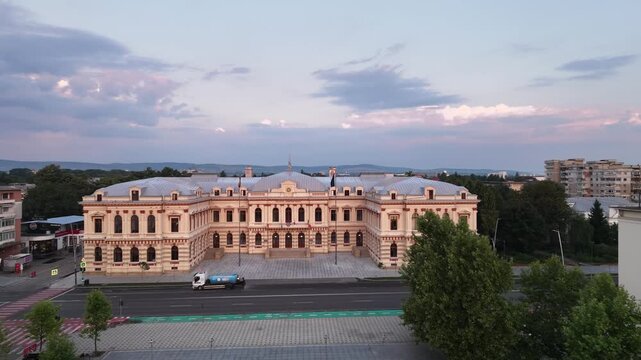 Aerial drone pan of the Bacău Prefecture, also known as the Administrative Palace &mdash; a grand neoclassical government building in Romania under a dramatic evening sky.