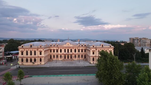 Aerial drone pan of the Bacău Prefecture, also known as the Administrative Palace &mdash; a grand neoclassical government building in Romania under a dramatic evening sky.