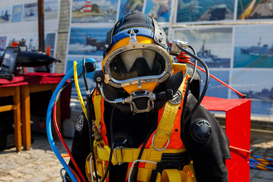 Mannequin dressed in a vintage diving suit with helmet and equipment on display outdoors, showcasing historic scuba diving gear