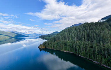 Fototapeta premium Tranquil Harrison Lake Panorama With Forested Shoreline and Mountain Reflections in British Columbia, Canada
