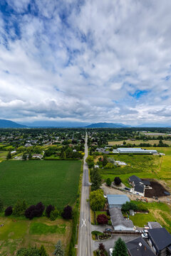 Aerial View Of Straight Rural Road Through Farmland And Homes Near Yarrow, Chilliwack, British Columbia, Canada