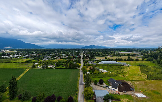 Aerial View of Yarrow Farmland and Road With Mountains and Clouds Near Chilliwack, British Columbia, Canada