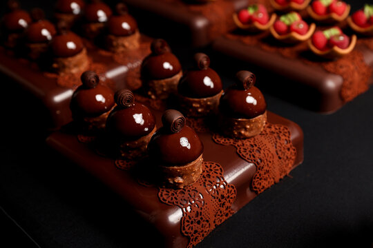 Luxury chocolate pastries with glossy glaze and decorative chocolate lace