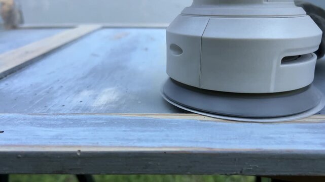 Close-up 4K shot of sanding wooden surface with power sander &ndash; woodworking renovation and DIY project footage