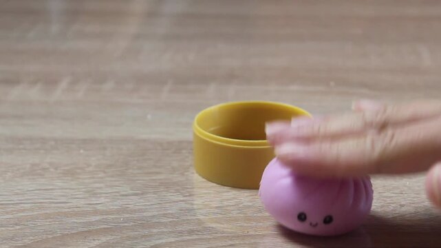 Girl pressing her finger to the table toy anti-stress dumpling