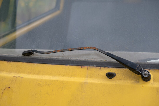 Rusty Windshield Wiper on an Old Yellow Vehicle