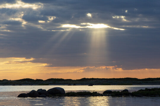 Seascape with sun rays and dramatic sky symbolizing death and mourning
