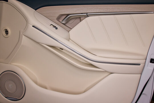 close-up of sleek modern car interior door panel with leather and plastic accents in a vehicle setting, showcasing a clean and contemporary design for automotive accessories.