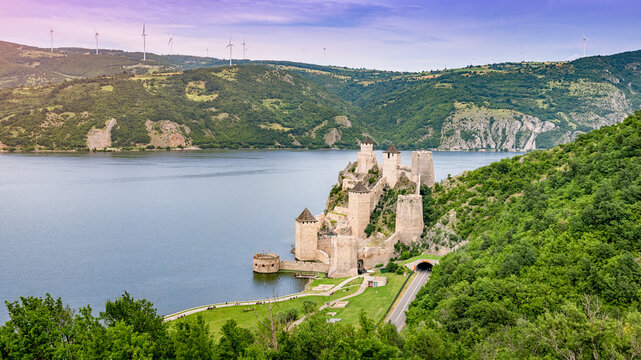 Medieval Golubac Fortress with its towers and walls along the Danube River, showcasing historic architecture and a tunnel road