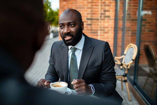 Business professional meeting over coffee at outdoor cafe