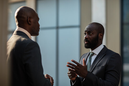 Two executives discussing business in office lobby