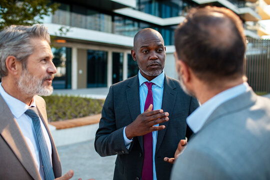 Business executives discussing strategy outside modern office building