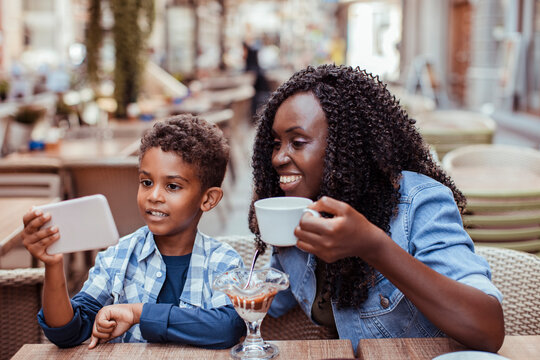 Mother and son taking selfie at outdoor cafe