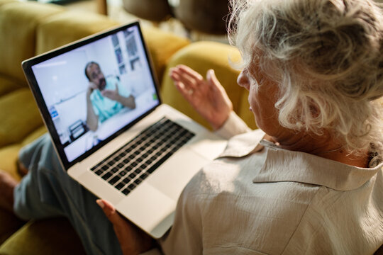 Senior woman consulting doctor via video call at home