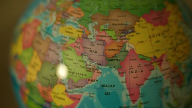 Close-up globe spins, highlighting Iran. Soft focus, gentle motion, warm lighting. Educational or travel-themed visual. No people, no animals, no plants shown