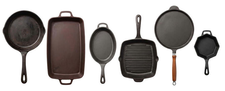 Collection of various cast iron cookware including skillets, a grill pan, roaster, and griddle arranged in a neat row showing different shapes, sizes, and textures from a top view