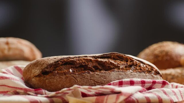Bread rye loaf cut with knife by hand, fresh homemade sourdough on wooden board, close-up macro shot