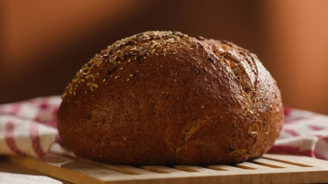 Bread multigrain loaf held in hands, whole wheat seeded crust with millet and seeds, close-up macro shot