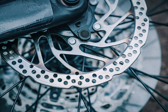 Bicycle disc brake rotor and wheel spokes showing mechanical detail, precision engineering, and modern cycling technology
