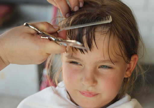 Cutting bangs for a girl of primary school age.